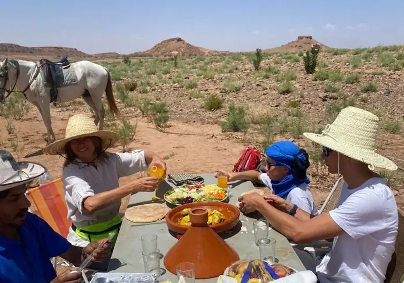 Riders sharing a traditional lunch in the shade during a horse ride