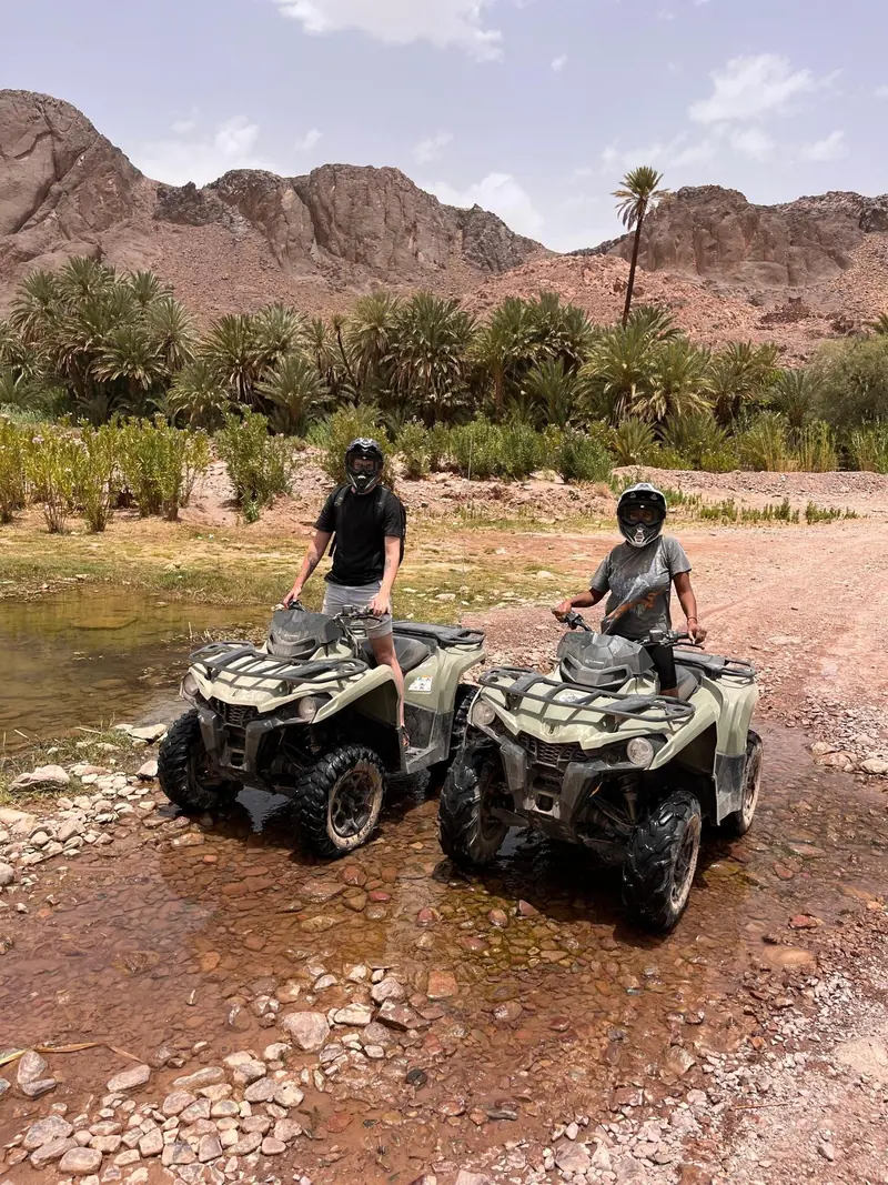 Two quads below the palm groves and cliffs of Fint