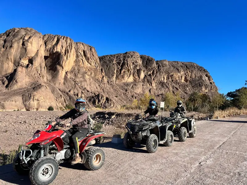 Une file de quads sous les falaises de grès pendant la journée complète