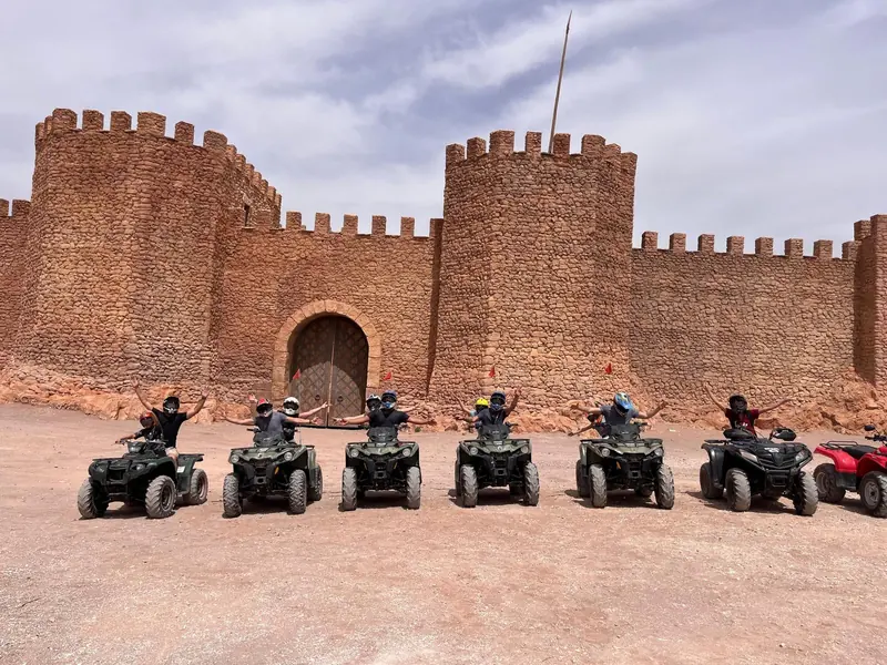 A group of quads parked below the crenellated walls of the film set